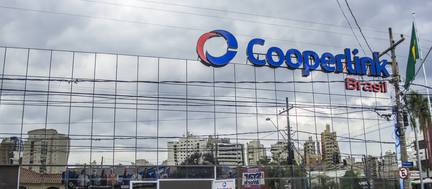 Sede da Cooperlink Brasil com letreiro em letra caixa sobre a fachada de vidro
