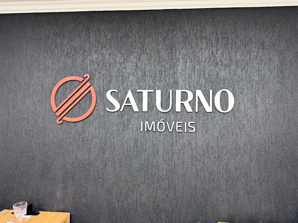 Logotipo Saturno Imóveis em letra caixa na parede da recepção